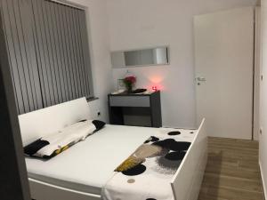 a bedroom with a black and white bed and a desk at Ornela Apartments in Durrës