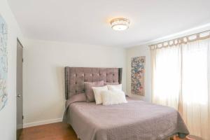 - une chambre avec un lit doté d'une couverture violette et d'une fenêtre dans l'établissement Smooth & Vivid Downtown Condo, à Ensenada