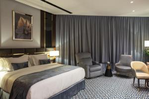 um quarto de hotel com uma cama grande e uma cadeira em STwin Hotel em Abha