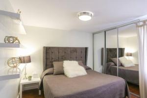 - une chambre avec un lit et un miroir dans l'établissement Smooth & Vivid Downtown Condo, à Ensenada