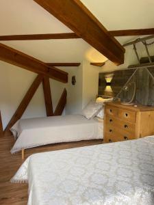 a bedroom with two beds and a wooden dresser at Duplex « les 7 Marmottes », Les Balcons de Recoin in Chamrousse