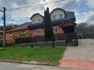 une grande maison orange avec une clôture dans l'établissement Green Dream Apartment Szaunával, à Miskolc