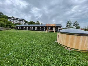 a large building with a wooden barrel in a field at Merida Residence in Bran