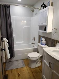 een badkamer met een toilet, een bad en een wastafel bij Laurel Haven a Modern Cabin Retreat near Gatlinburg in Cosby