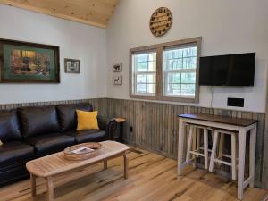 een woonkamer met een bank en een tafel bij Laurel Haven a Modern Cabin Retreat near Gatlinburg in Cosby