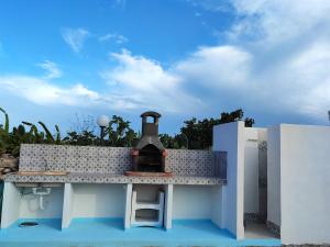 uma cozinha exterior com um fogão ao lado de uma casa em Appartamenti Za Barbara em Lampedusa