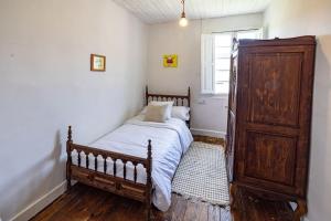 1 dormitorio con cama y tocador de madera en Casona de la Ribeira Sacra en Pobra do Brollón