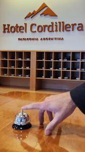 a hand points to a hotel container on the floor at Hotel Cordillera in El Bolsón