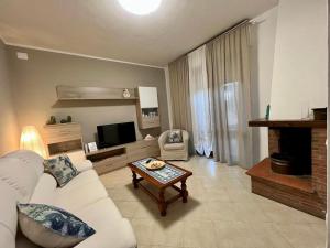 a living room with a white couch and a table at Appartamento Sunflower in Viareggio