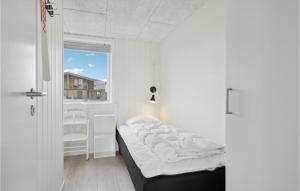 a small bedroom with a bed and a window at Two-Bedroom Holiday Home Ringkøbing 04 in Søndervig +18 photos
