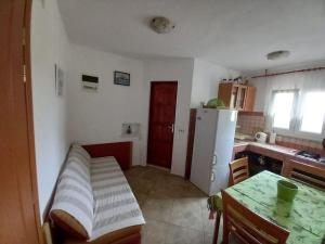 eine Küche mit einem Tisch und einem weißen Kühlschrank in der Unterkunft Apartments Belvedere - A3 in Nečujam
