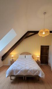 um quarto com uma cama grande e um lustre em LA MAISON DE NOS PARENTS em Gonnehem