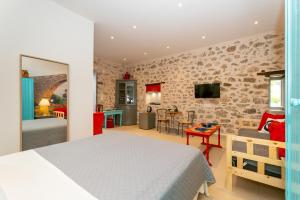 Ydor apartment في هيدرا: غرفة نوم مع سرير وغرفة معيشة