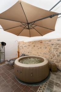 a large umbrella over a hot tub in a room at Ydor apartment in Hydra