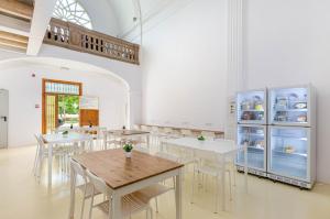 una sala da pranzo con tavoli, sedie e frigorifero di Urban Hostel Palma - Albergue Juvenil - Youth Hostel a Palma de Mallorca
