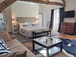 a living room with a bed and a coffee table at Demeure Les Aiglons, Chambres d'hôtes & Spa in Fontainebleau