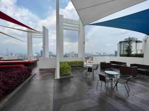 een dakterras met tafels en stoelen in een gebouw bij Bliss Cool Home 2Rooms 4Pax 1CarPark 24H7D Easy Self Access in Kuala Lumpur