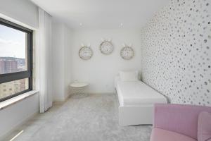 a white room with a couch and a window at Family Condo: Urban Retreat w/Parking, AC, Elevator in Great Location in Lisbon