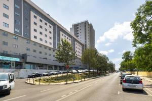 uma rua com carros estacionados ao lado de um edifício em Family Condo: Urban Retreat w/Parking, AC, Elevator in Great Location em Lisboa