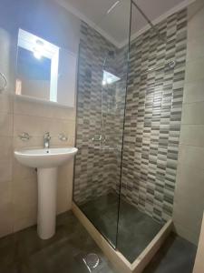 een badkamer met een wastafel en een glazen douche bij Maria's Modern Apartment , Monemvasia in Monemvasia