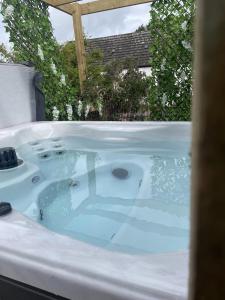 a jacuzzi tub with blue water in a yard at Morton Cottage in Thornhill
