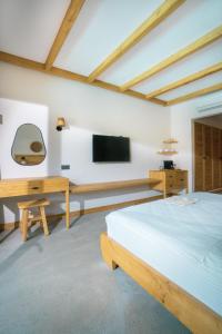 um quarto com uma cama, uma secretária e uma televisão em The Pearl Ölüdeniz em Oludeniz