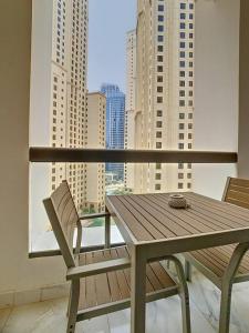 - une table et des chaises en bois sur un balcon avec des bâtiments dans l'établissement Key View - Murjan 2, JBR, à Dubaï