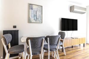 a dining room with a table and chairs and a tv at Modern Living in Nisantasi Citys Mall in Istanbul