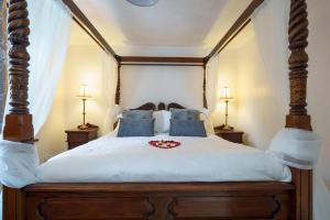 a bedroom with a large bed with blue pillows at Dalgarnock Cottage in Thornhill