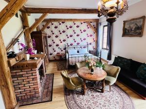 a living room with a table and a fireplace at Nostalgia Poganice in Potęgowo