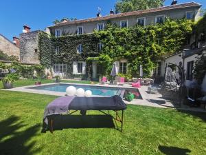 a pool in the yard of a house at Demeure Les Aiglons, Chambres d'hôtes & Spa in Fontainebleau