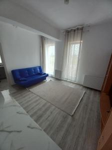 een woonkamer met een blauwe bank in een lege kamer bij Twins Residence 2 APART HOTEL Ap 3 2 rooms in Chiajna