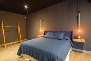 a bedroom with a purple bed with two lamps at Brand New Gorgeous Industrial Loft in Downtown Ens in Ensenada