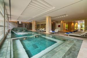 a large swimming pool in a hotel lobby at Aparthotel Costa Encantada in Lloret de Mar