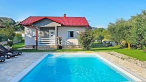 a house with a swimming pool in front of a house at Holiday Home Natura with private pool in Mostar