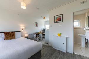 a bedroom with a white bed and a bathroom at Beaches Chalets in Prestatyn