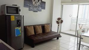 a living room with a couch and a microwave at Linda Suite Tonsupa 2 cuadras del mar 2 piscinas Av. Club del Pacifico in Tonsupa