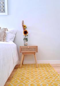 a table with a vase on it next to a bed at Boavista Luxury Villas in Porto