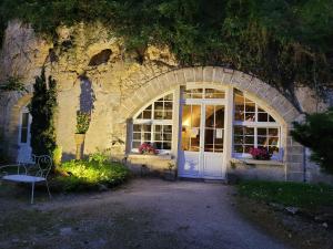 un edificio con una puerta blanca y una ventana en Chambres d'Hôtes Troglodytes Le Clos de L'Hermitage, en Amboise
