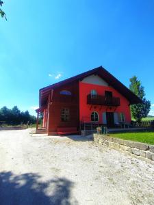 a large red barn with a black roof at Haškovna - tradice zájezdního hostince u Prachovských skal in Ohaveč