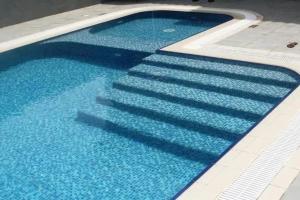 a swimming pool with blue water and stairs in it at Key View - Silicon Star in Dubai