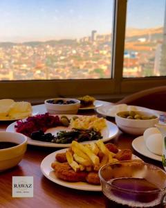 une table avec des assiettes de nourriture sur une table dans l'établissement Rawaz Hotel & Motel, à Sulaymaniyah