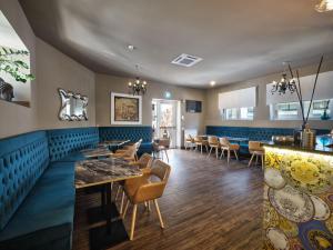 a restaurant with blue booths and tables and chairs at Hotel Giulietta in Verona