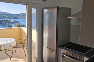 eine Küche mit einem Kühlschrank aus Edelstahl und einem Tisch in der Unterkunft Apartments Belvedere - A4 in Nečujam
