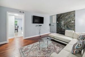 a white living room with a couch and a table at Pet-Friendly Mount Rainier Home with Gas Grill! in Mount Rainier