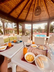 a table with breakfast food on it under a pavilion at Hotel Villa Rosa in Porto Azzurro