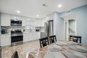 a kitchen with white cabinets and a table with plates on it at Pet-Friendly Mount Rainier Home with Gas Grill! in Mount Rainier