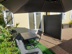 a patio with an umbrella and a table and chairs at Gîte David Jacky in Fortschwihr