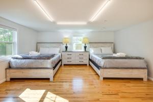 2 łóżka w sypialni z drewnianą podłogą w obiekcie Charming Yarmouth Home with Patio and Fire Pit! w mieście Yarmouth