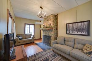 a living room with a couch and a fireplace at Lakefront Adirondack Getaway with Beach and Kayaks! in Lake Pleasant